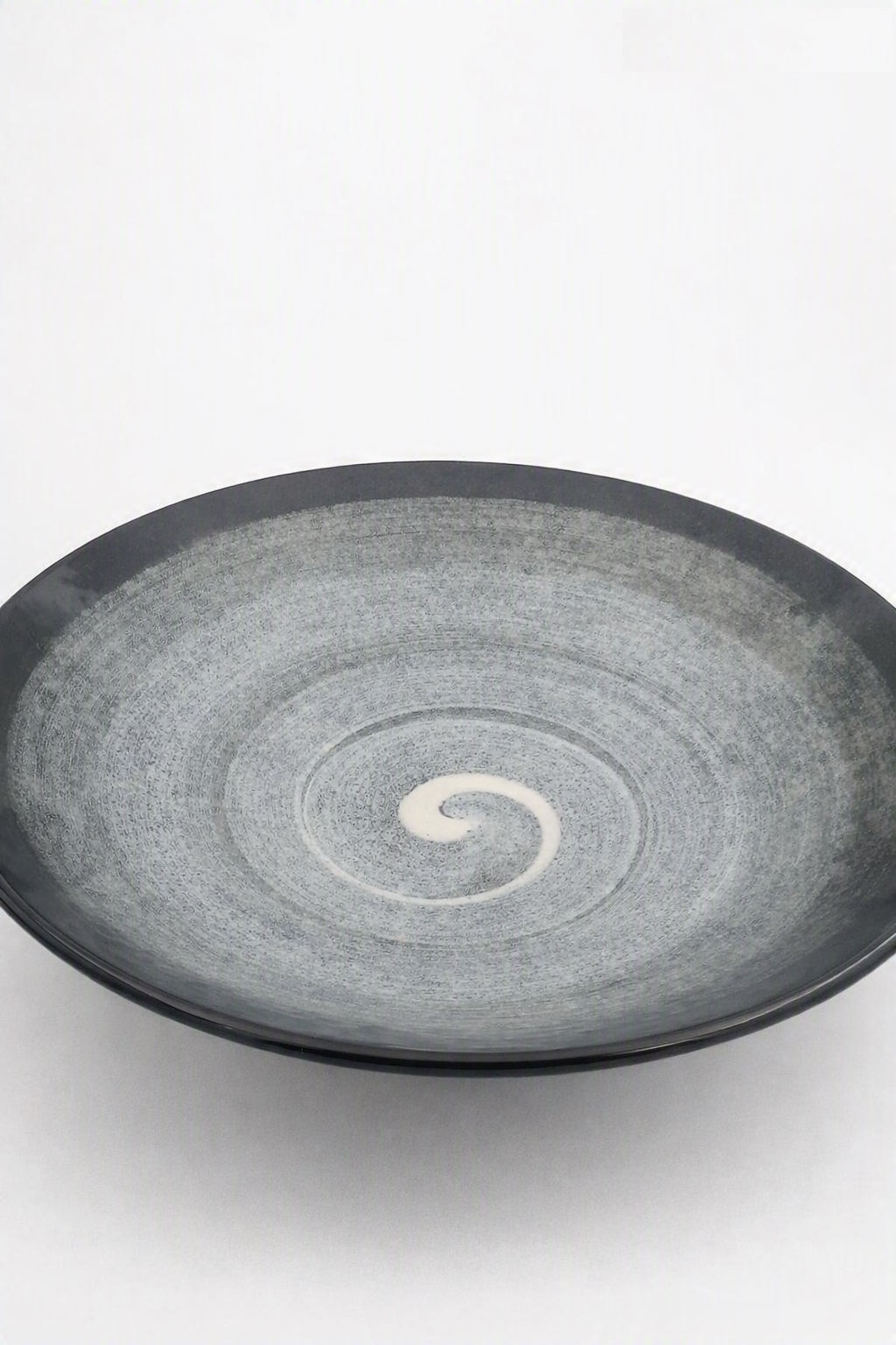 Saladier en céramique japonaise noire vu de dessus révélant son élégant motif en spirale