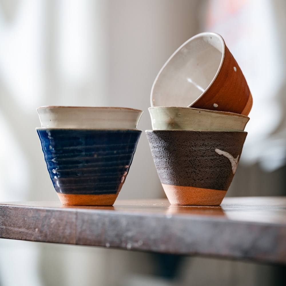 Tasses à thé japonaises en céramique empilées les unes sur les autres, montrant les motifs et les couleurs
