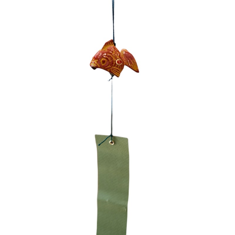 Clochette japonaise Furin en forme de poisson, présentée dans un décor japonais traditionnel
