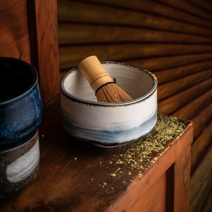 Bol à matcha japonais Harukasumi en céramique blanche, présenté dans une maison de thé traditionnelle