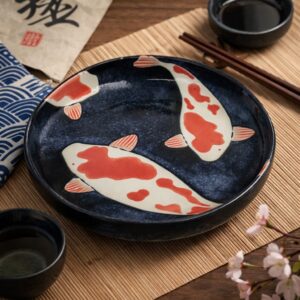 Assiette japonaise en céramique décorée d’une carpe Koi, présentée sur une table japonaise